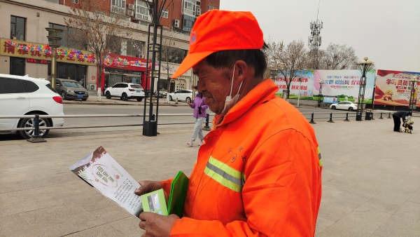 附件五：河曲县一名环卫工人正在认真阅读《黄河保护法》宣传资料.jpg